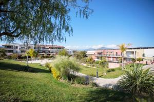 park z budynkami w tle z trawą i roślinami w obiekcie DOMAINE DES ROSES AP4222 by Riviera Holiday Homes w Nicei