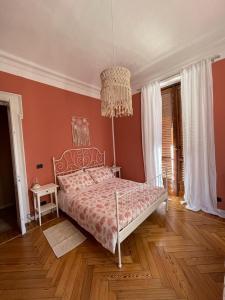 a bedroom with a bed and a chandelier at La Petite Maison de la Ville in Turin