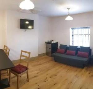 uma sala de estar com um sofá e uma mesa em Sparks - Family Suite in Canalside Guesthouse em Burnley