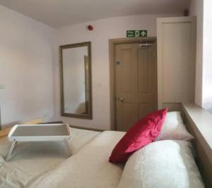 ein Schlafzimmer mit einem Bett mit einem roten Kissen darauf in der Unterkunft Turner - En-suite Room in Canalside Guesthouse in Burnley