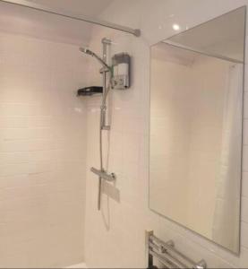 a shower in a bathroom with a mirror at Turner - En-suite Room in Canalside Guesthouse in Burnley