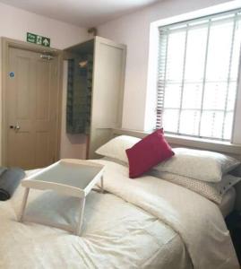 Habitación con cama con almohada roja. en Turner - En-suite Room in Canalside Guesthouse en Burnley