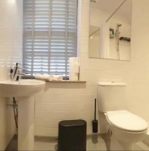 a bathroom with a sink and a toilet and a mirror at Turner - En-suite Room in Canalside Guesthouse in Burnley