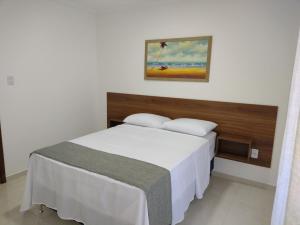 a bedroom with a bed and a painting on the wall at Residencial Secret Point in Praia do Frances +9 photos