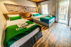 a bedroom with two beds and a desk in it at Inanlar Premium Suites & Villas in Uzungöl