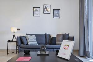 un soggiorno con divano blu e tavolo di Shelley Apartments by Wonderful Italy a Genova