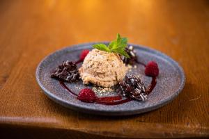 - un dessert sur une assiette avec des fraises et du chocolat dans l'établissement Mittelburg Wellnesshotel, à Oy-Mittelberg