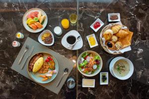 una mesa cubierta con platos de comida y tazones de comida en Grand Richmond Stylish Convention Hotel en Nonthaburi