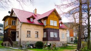 a large house with a red roof at HELLO Apartamenty - Pozytywka z widokiem na Śnieżkę in Karpacz
