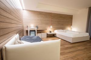 sala de estar con 2 camas blancas y lavamanos en B612 en Levico Terme