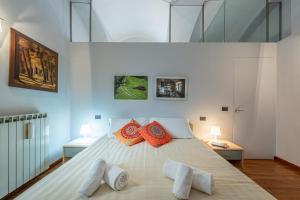 een slaapkamer met een groot wit bed met oranje kussens bij L'Antico Cedro Apartment in Alba