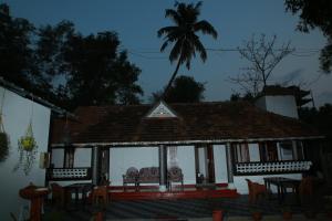 a house with chairs in front of it at night at Marari Casa Almare in Mararikulam