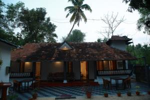 a house with a roof with tables and chairs at Marari Casa Almare in Mararikulam