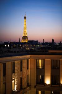 a large clock tower towering over a city at night at Hotel du Collectionneur Arc de Triomphe in Paris