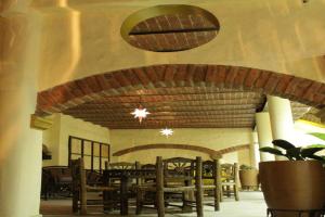 a dining room with tables and chairs and a ceiling at OYO Hotel Castillo Santa Cecilia in Tapalpa
