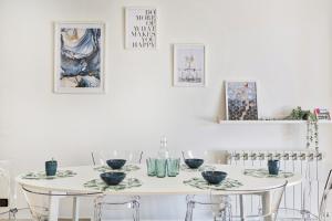 una sala da pranzo bianca con tavolo e sedie bianchi di Shelley Apartments by Wonderful Italy a Genova