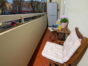 un balcón con un banco y una mesa con flores en Apartman Point en Pula