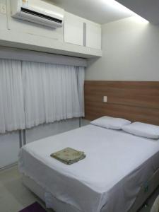 1 dormitorio con 1 cama grande con sábanas blancas en Estúdio Ibiza em Jatiúca, en Maceió