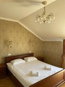 a bedroom with a bed with two white towels on it at Complex Zolota Pidkova in Zolochiv