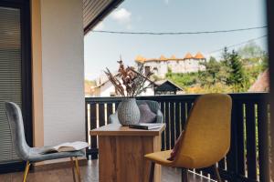 a balcony with two chairs and a table with a vase at Gostišče Koren in Žužemberk