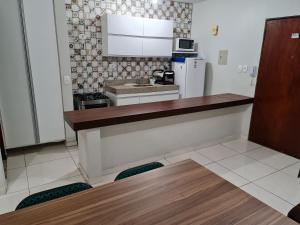 a kitchen with a counter and a refrigerator at Estúdio Ibiza em Jatiúca in Maceió