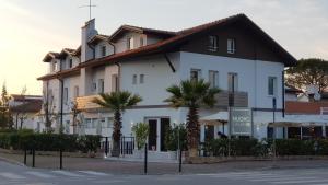 un bâtiment blanc avec des palmiers devant lui dans l'établissement Hotel Nuovo Cason, à Cavallino-Treporti