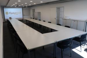a conference room with tables and chairs and a projection screen at Hotel Garni Fischerfleck in Ismaning near Munich in Ismaning