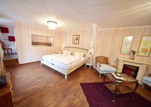 a bedroom with a white bed and a fireplace at Märchenhotel in Bernkastel-Kues