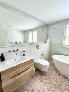 La salle de bains est pourvue d'une baignoire, d'un lavabo et de toilettes. dans l'établissement Redland Suites - Apartment 1, à Bristol