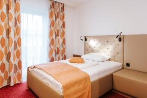 ein Hotelzimmer mit einem Bett und einem Fenster in der Unterkunft Hotel Der Stockinger in Premstätten + 21 Fotos