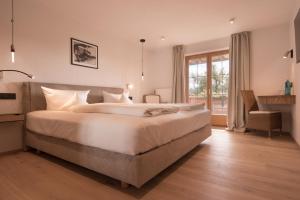 a large bedroom with a large bed and a window at Mittelburg Wellnesshotel in Oy-Mittelberg