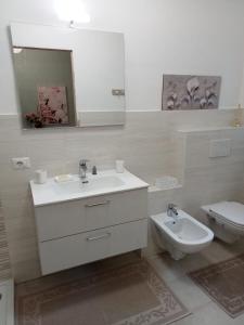 a bathroom with a sink and a toilet and a mirror at Casa marlene in Orino