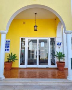 a white door leading to a room with a blue wall at Apartamentos Turisticos Alagoa Praia in Altura