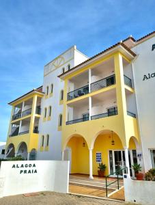 a large white building with a large window at Apartamentos Turisticos Alagoa Praia in Altura