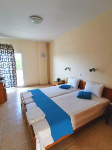 a large bedroom with a large bed with blue pillows at Rodica Studios in Kallithea Halkidikis