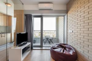 - un salon avec une télévision et une grande fenêtre dans l'établissement Dragon Stadium Studio w Balcony by LovelyStay, à Porto