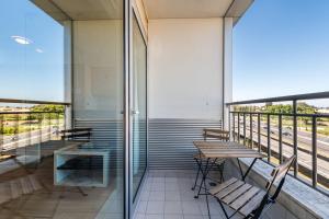 a balcony with tables and chairs on a building at Dragon Stadium Studio w Balcony by LovelyStay in Porto