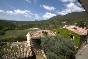 Luxurious Provencal Village House, Walk to Village Pool في روستريل: مبنى مغطى باللبلاب مع جبال في الخلفية