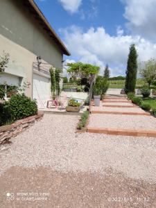a backyard with a gravel driveway and a garage at Mas de Grezes in Gaillac