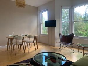 un soggiorno con tavolo, sedie e TV di Lovely spacious 1-bedroom flat in Tufnell Park close to Central London a Londra