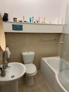 y baño con aseo blanco y lavamanos. en Lovely spacious 1-bedroom flat in Tufnell Park close to Central London en Londres