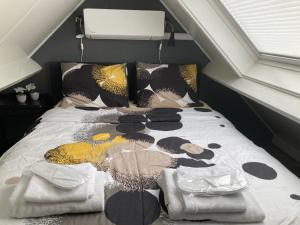 a bed with a comforter and pillows on it at Design BB Bed Bike Family Cottage in Spakenburg in Spakenburg