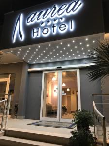 a hotel with a neon sign on the front of it at Aurea Hotel in Tortoreto Lido