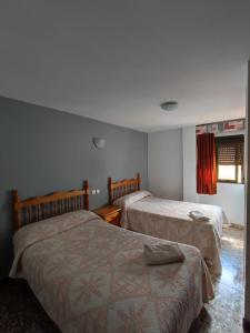 a bedroom with two beds and a window at Pensión Pradera in Mesones +25 photos