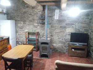 Habitación con pared de piedra y estufa de leña. en Cabaña del Zapatero El Bierzo Ponferrada, en Valdecañada