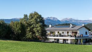 a house on a hill with mountains in the background at Apartments Elisir in Castelrotto