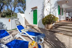 un par de sillas azules en un porche con una puerta verde en Casa Maria Elena, en Cala Santanyi