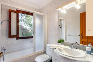 a bathroom with a sink and a toilet and a window at Casa Maria Elena by dracmallorca in Cala Santanyi +45 photos