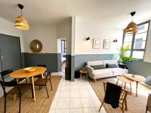 a living room with a table and a couch at L'Appart du Palais A 150m de la Grande Plage in Les Sables-dʼOlonne
