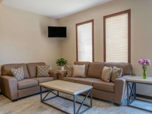 a living room with two couches and a table at Super 8 by Wyndham Clinton in Clinton